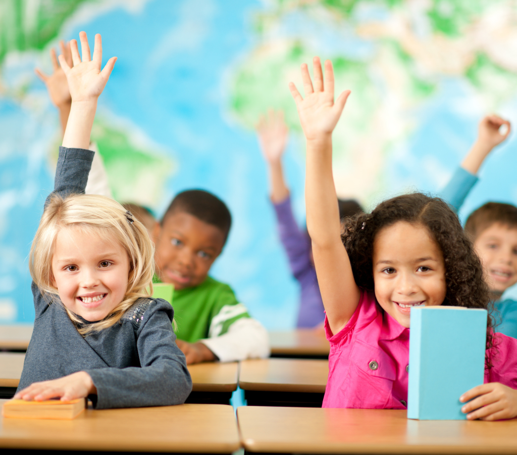 young students holding up hands in air